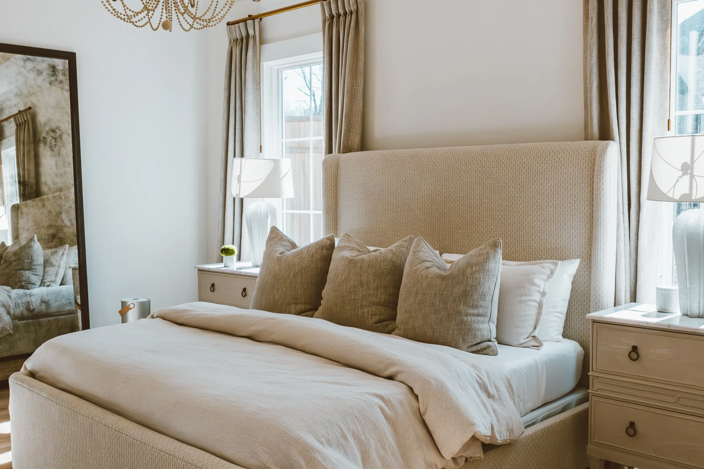 Primary bedroom with a beaded chandelier and linen bed