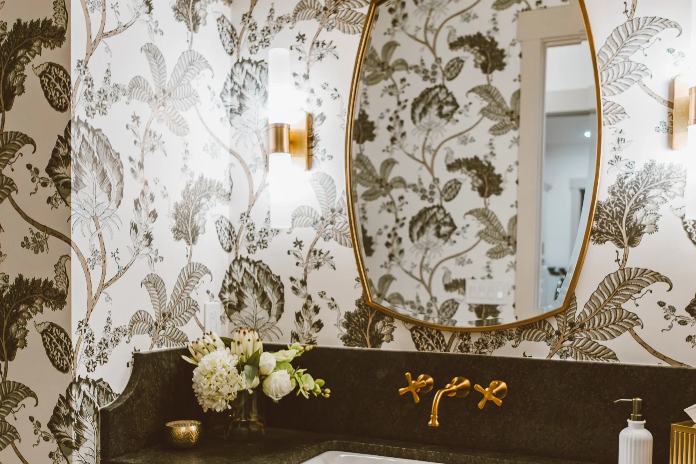 Powder room with botanical wallpaper and a floating stone vanity