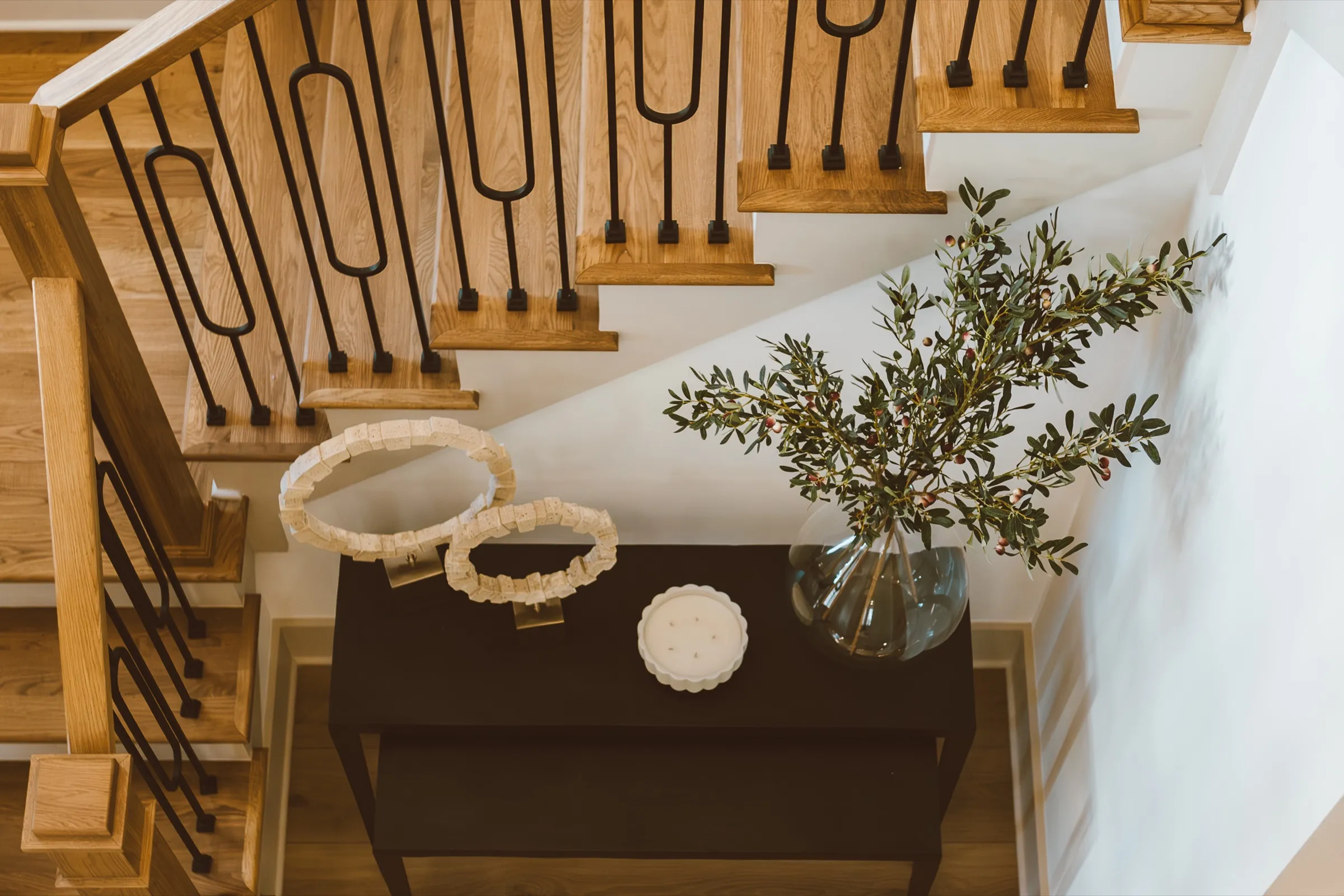 Oak staircase with iron balusters above an entry console